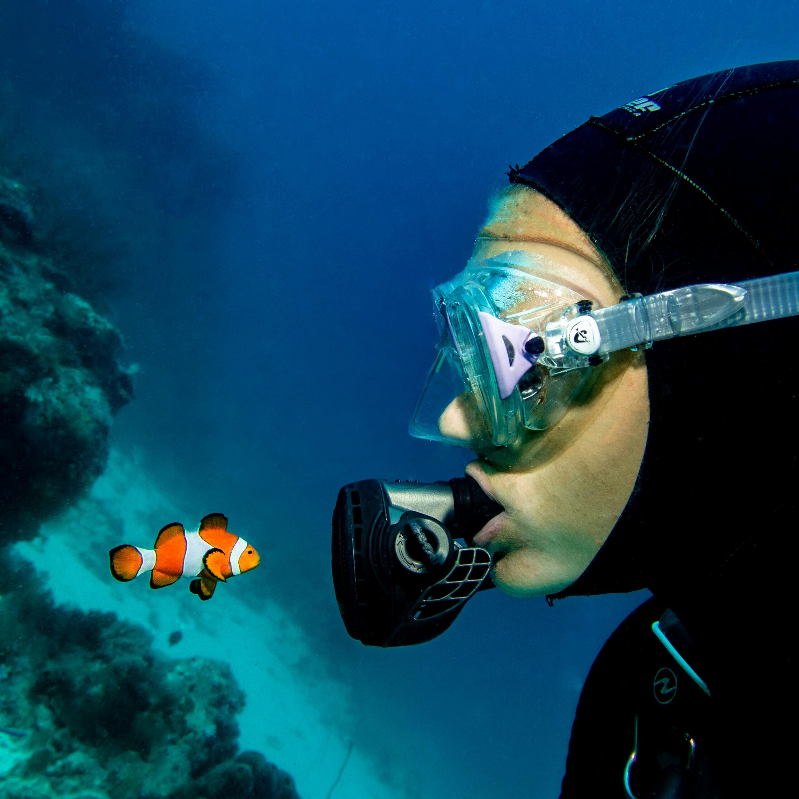 pexels photo 4777687 4777687 A scuba diver wearing goggles closely observes a clownfish in the ocean.